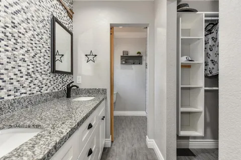 a bathroom with a granite countertop sink and a mirror