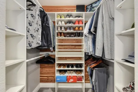 a view of walk in closet with clothes and shoes