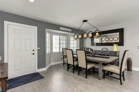 a view of a a dining room with furniture window and wooden floor