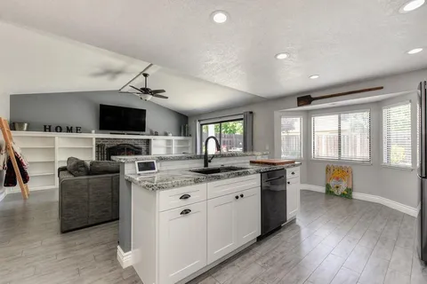 a kitchen with stainless steel appliances granite countertop sink stove top oven and cabinets