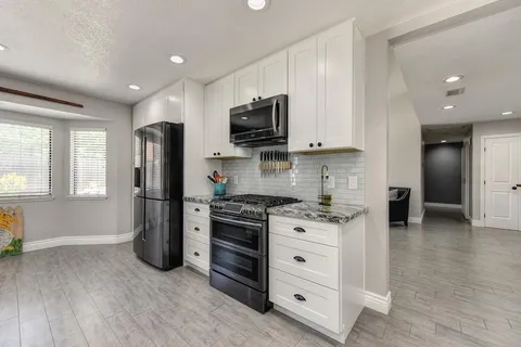 a kitchen with stainless steel appliances granite countertop a stove a refrigerator and a microwave