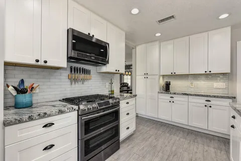 a kitchen with granite countertop a stove and a sink