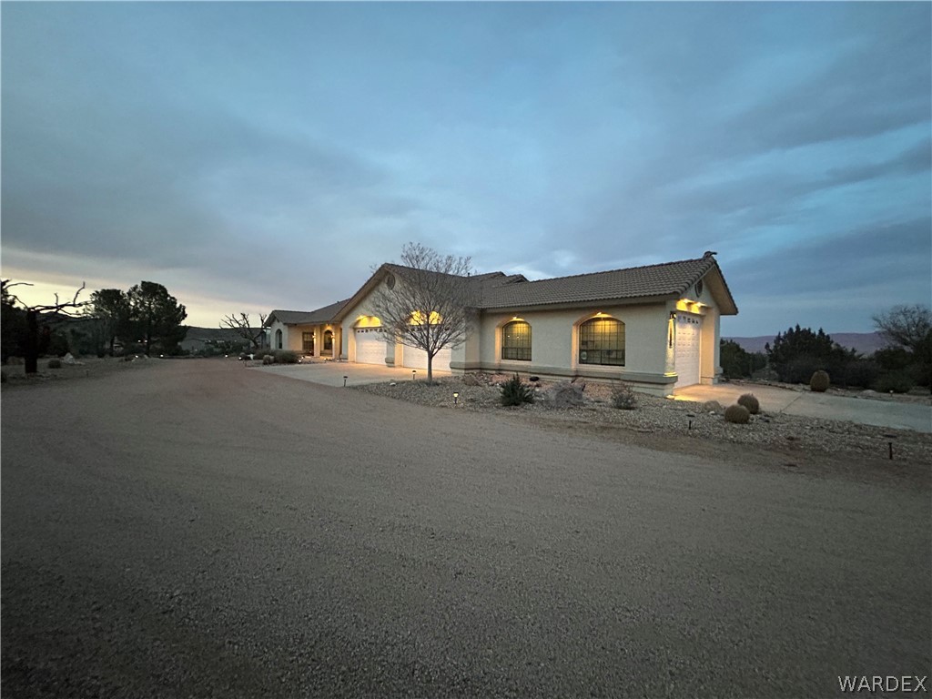5840 North Cedar Ridge Lane Kingman, AZ 86409 - Photo 2 of 89 a front view of a house with a yard and garage