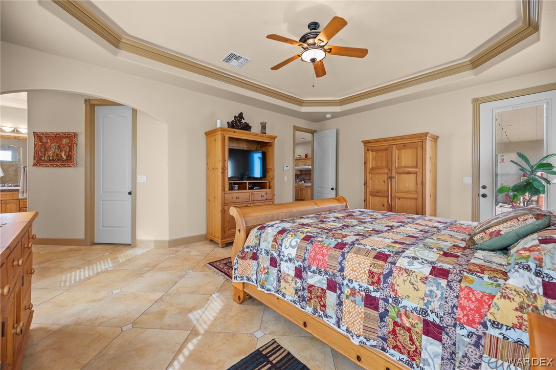 5840 North Cedar Ridge Lane Kingman, AZ 86409 - Photo 35 of 89 a bedroom with a bed and a chandelier