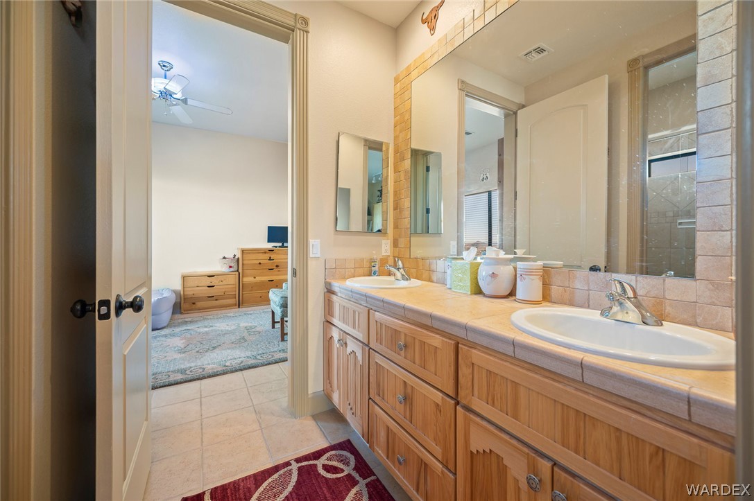 5840 North Cedar Ridge Lane Kingman, AZ 86409 - Photo 50 of 89 a bathroom with a granite countertop sink and a mirror