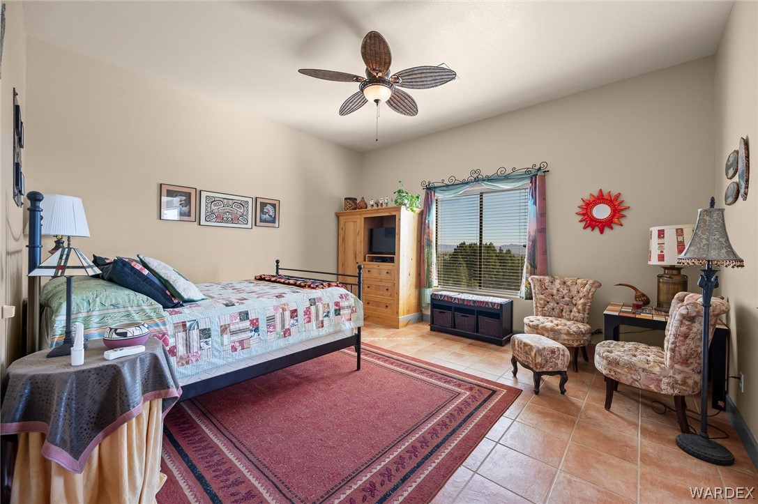5840 North Cedar Ridge Lane Kingman, AZ 86409 - Photo 56 of 89 a bedroom with a bed a couch and a chandelier
