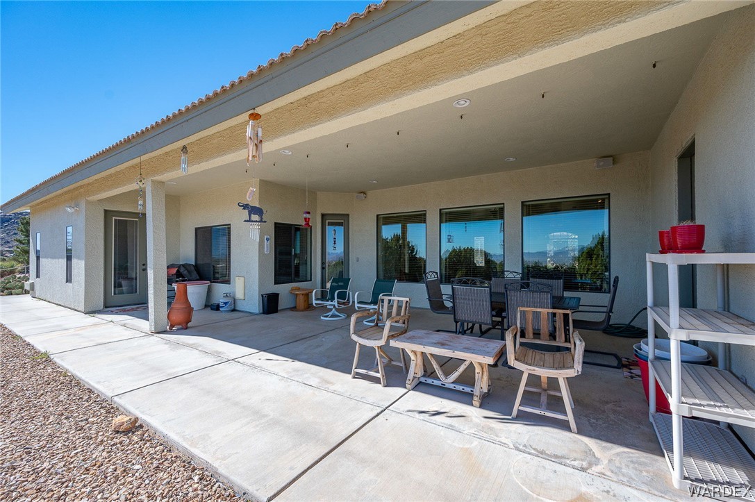 5840 North Cedar Ridge Lane Kingman, AZ 86409 - Photo 69 of 89 a view of a patio with dining table and chairs and potted plants