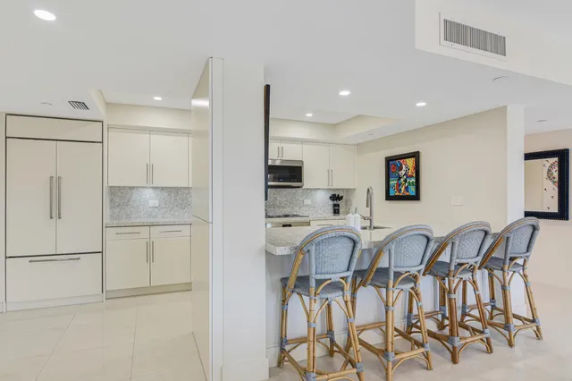 a bedroom with a bed couches chair and painting on the wall