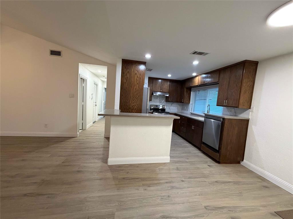 5020 Timber Creek Road Flower Mound, TX 75028 - Photo 4 of 15 a large kitchen with stainless steel appliances granite countertop a large counter top and a stove top oven
