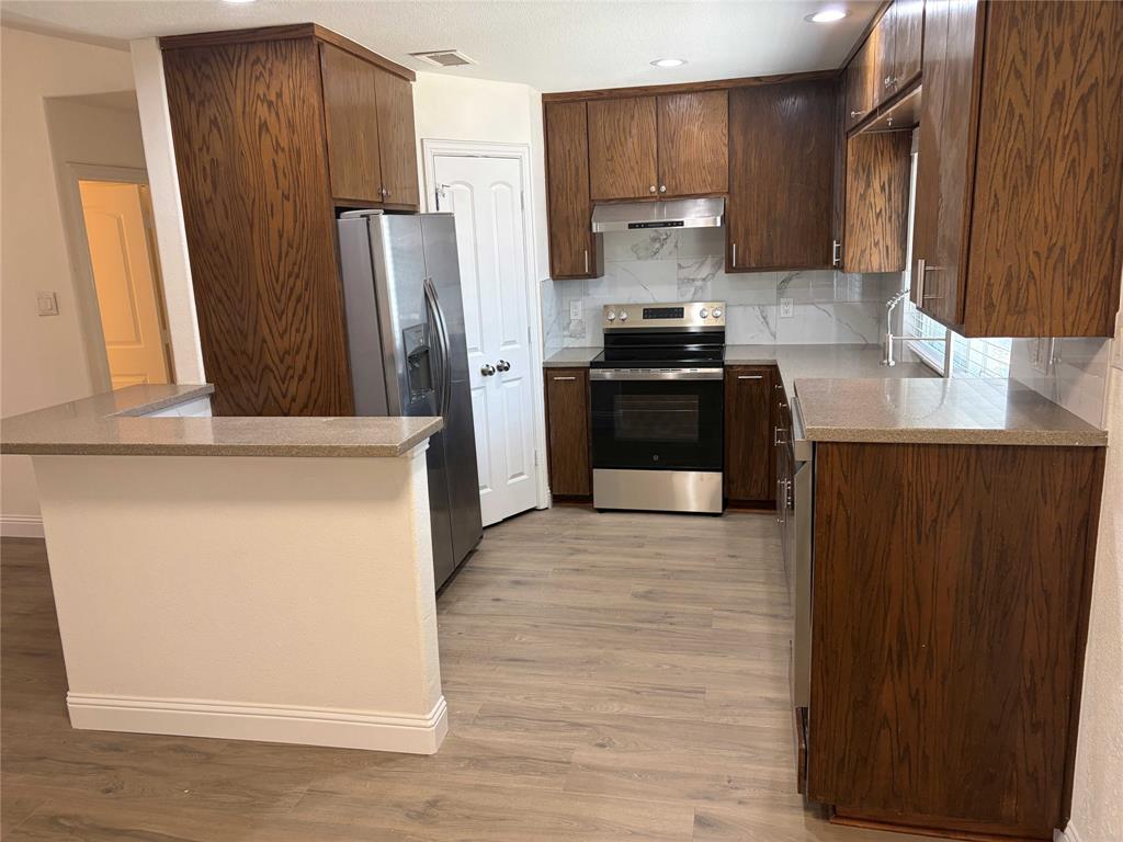 5020 Timber Creek Road Flower Mound, TX 75028 - Photo 5 of 15 a kitchen with stainless steel appliances a refrigerator and a stove