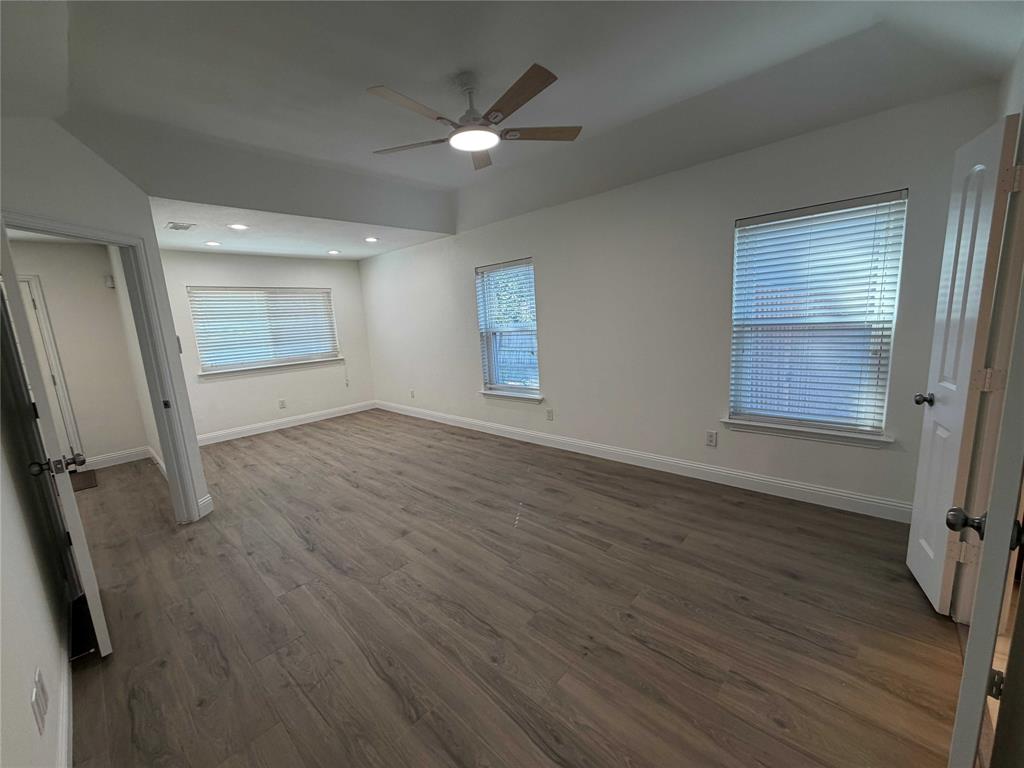5020 Timber Creek Road Flower Mound, TX 75028 - Photo 8 of 15 an empty room with wooden floor cabinet and windows