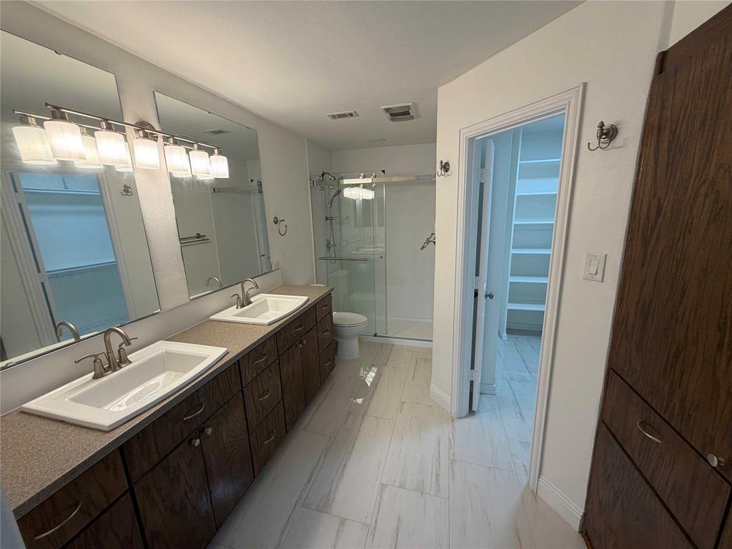 5020 Timber Creek Road Flower Mound, TX 75028 - Photo 9 of 15 a spacious bathroom with a double vanity sink a large mirror and shower