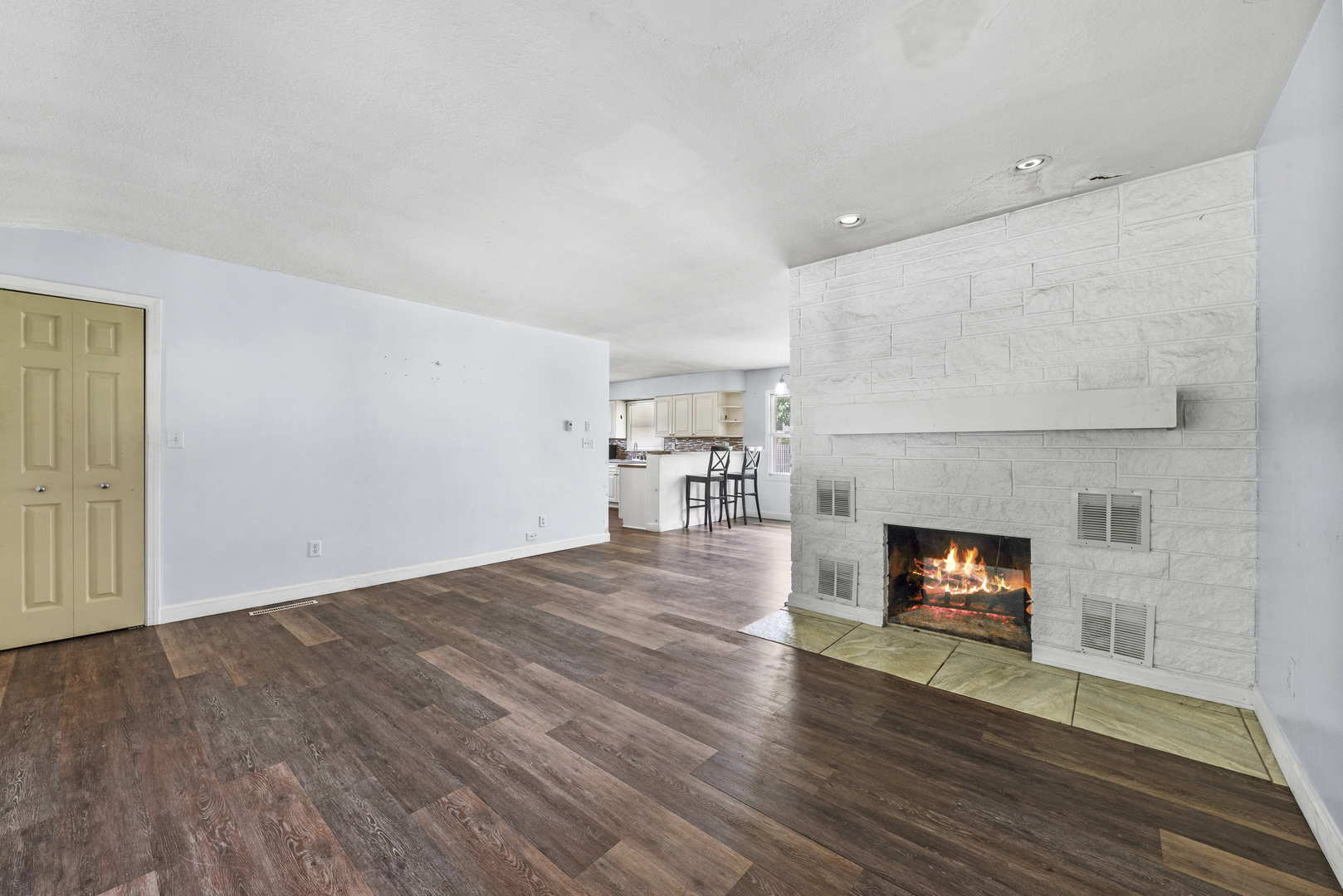2 Baker Street Kankakee, IL 60901 - Photo 5 of 17 an empty room with wooden floor fireplace and windows