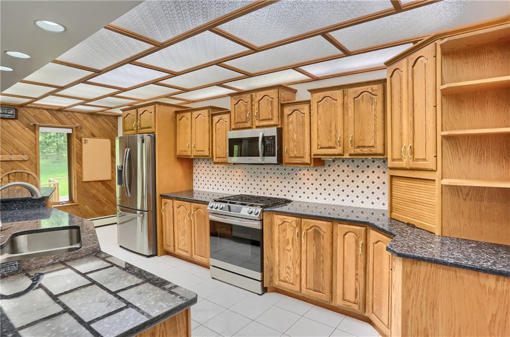 481 Chicora Fenelton Road Chicora, PA 16025 - Photo 14 of 50 Kitchen view featuring extensive cabinetry, oversized island seating, and generous workspace.
