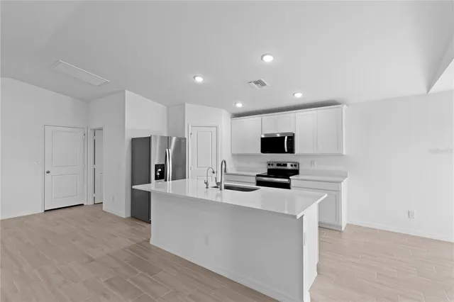 a kitchen with stainless steel appliances a refrigerator and a stove top oven