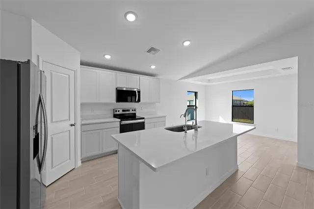 a kitchen with refrigerator and microwave