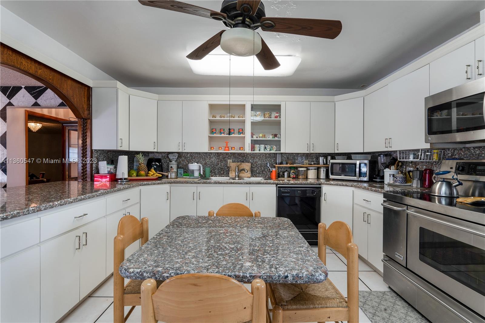 30 Southwest 21st Road Miami, FL 33129 - Photo 17 of 30 a kitchen with a dining table chairs stainless steel appliances and cabinets