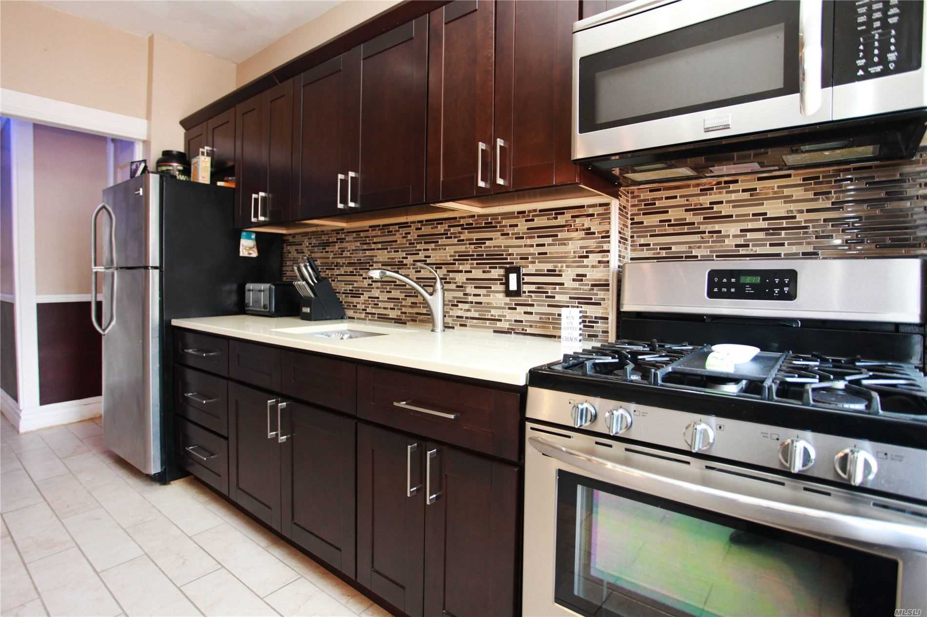 a kitchen with stainless steel appliances wooden cabinets and a stove top oven