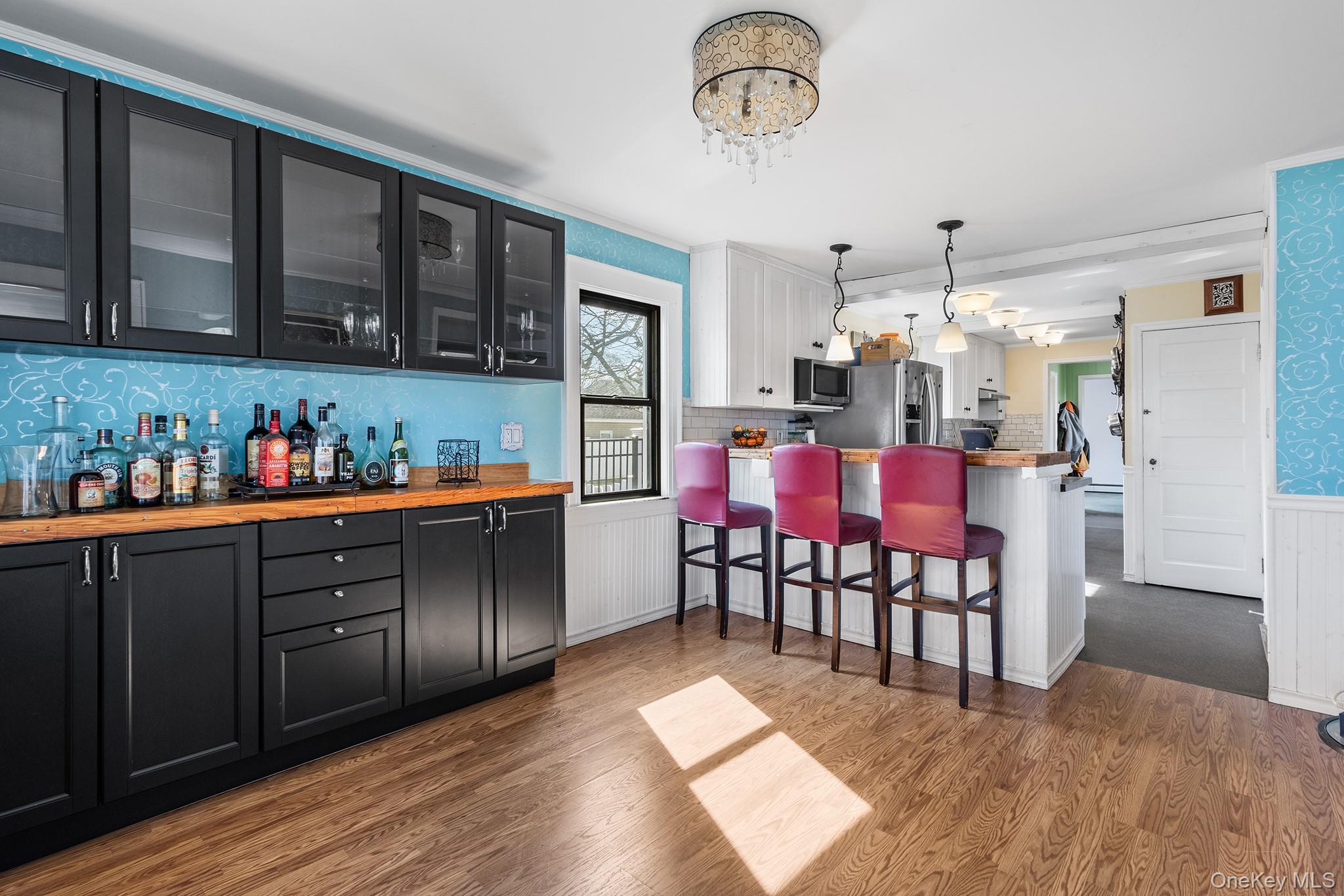 42 Robertson Road Lynbrook, NY 11563 - Photo 11 of 23 a kitchen with stainless steel appliances kitchen island granite countertop a table chairs in it and wooden floors