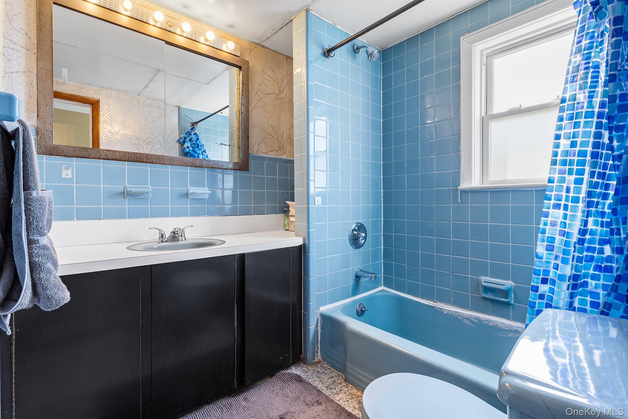 42 Robertson Road Lynbrook, NY 11563 - Photo 17 of 23 a bathroom with a sink a bathtub a mirror a vanity and a shower