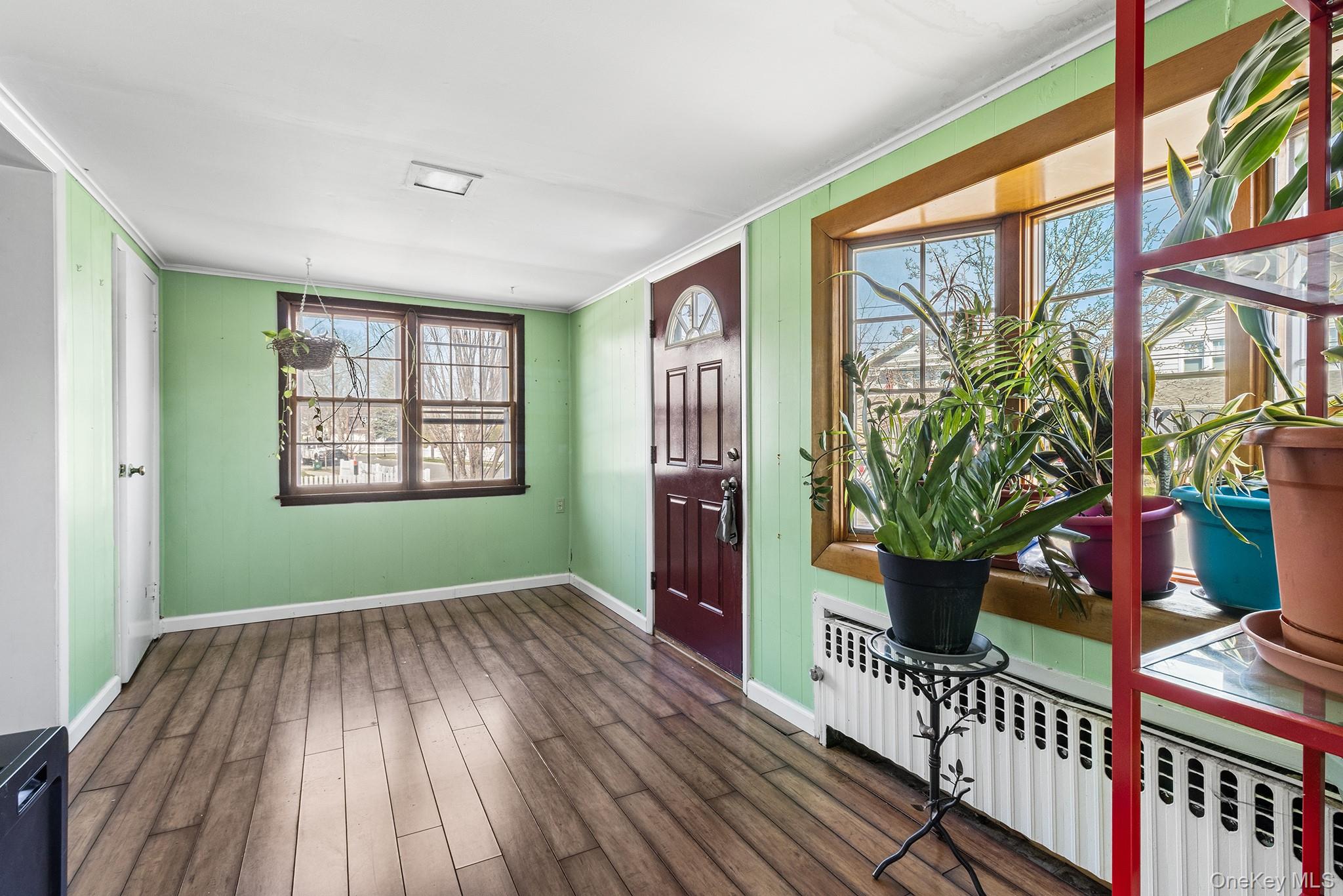 42 Robertson Road Lynbrook, NY 11563 - Photo 4 of 23 a view of an empty room with window and wooden floor