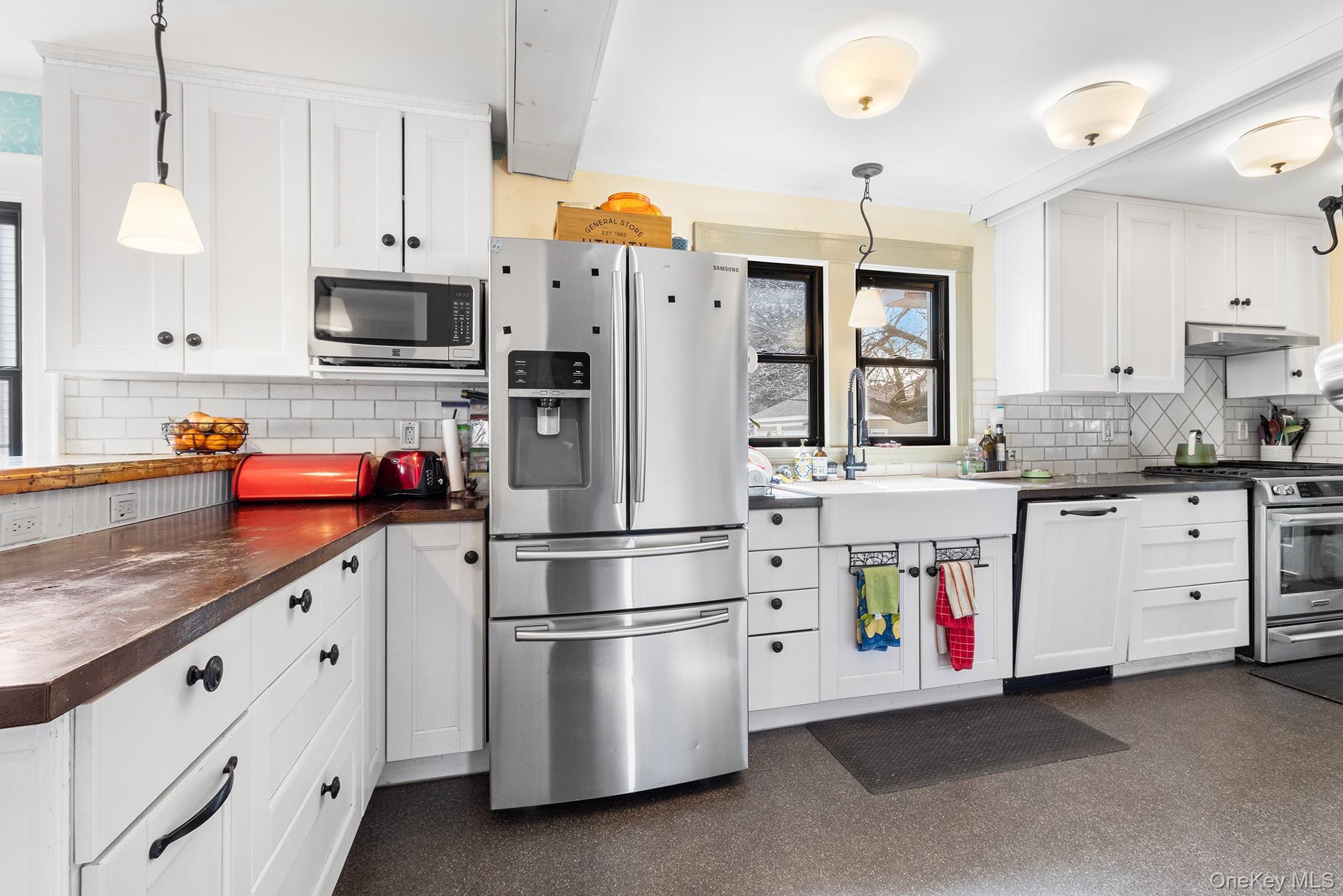 42 Robertson Road Lynbrook, NY 11563 - Photo 7 of 23 a kitchen with stainless steel appliances white cabinets and a refrigerator