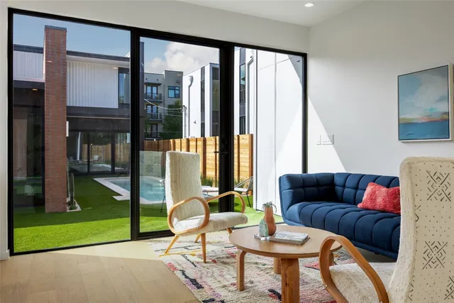 a living room with fireplace furniture and a large window