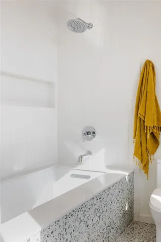 a bathroom with a granite countertop sink and a toilet