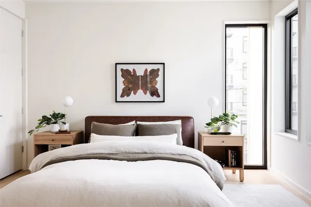 a bedroom with a bed and a painting on the wall