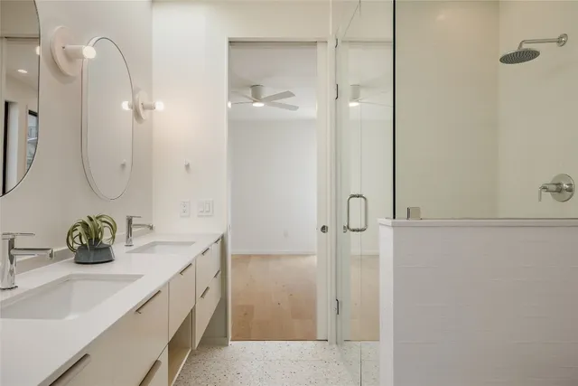 a bathroom with a double vanity sink a shower and a mirror