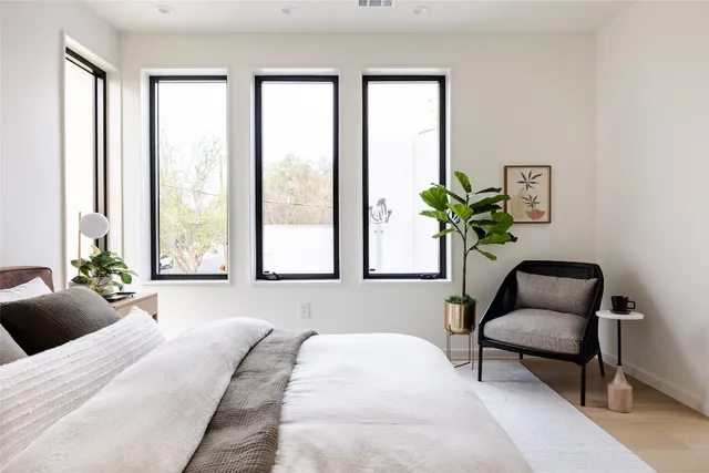 a bedroom with a bed and a couch next to a window
