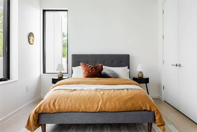 a bed sitting in a bedroom next to a window