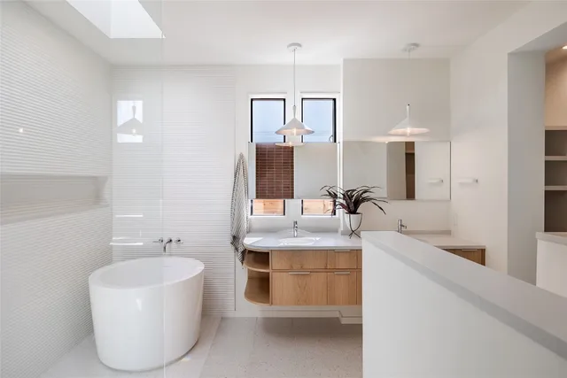 a bathroom with a tub sink and mirror