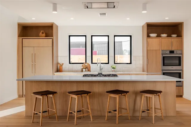 a kitchen with cabinets a sink dishwasher window and chairs