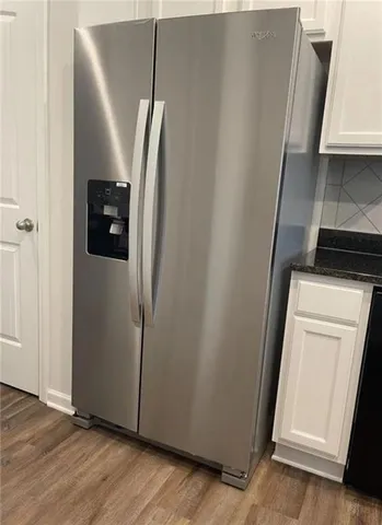 an entryway with wooden floor and cabinets