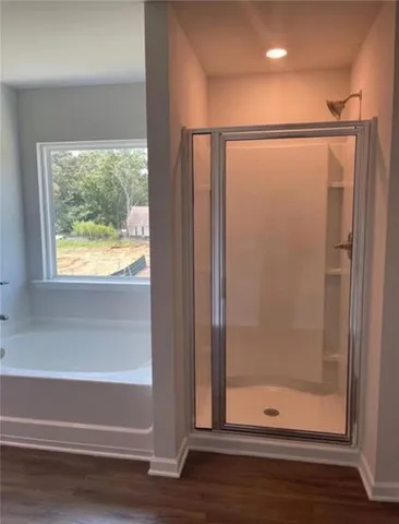 a bathroom with a glass shower door and a window