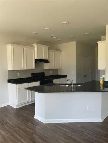 a kitchen with stainless steel appliances granite countertop a sink stove and wooden floor