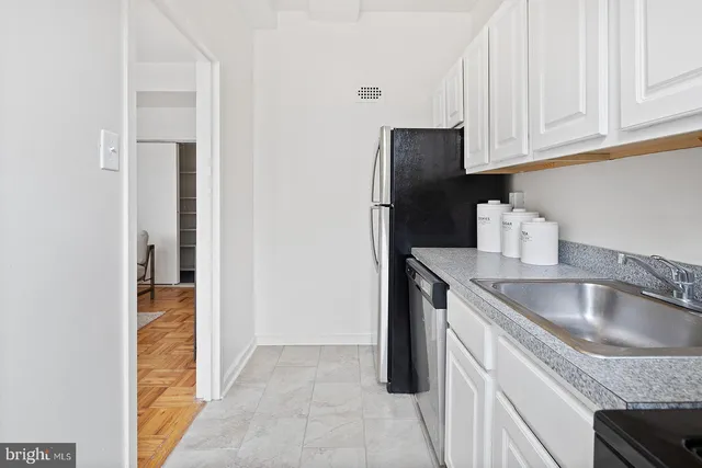 a kitchen with stainless steel appliances granite countertop a sink and a refrigerator