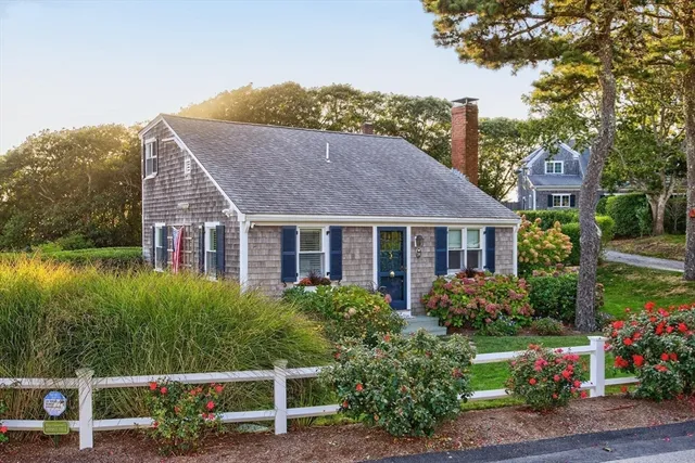 a aerial view of a house with a yard table and chairs