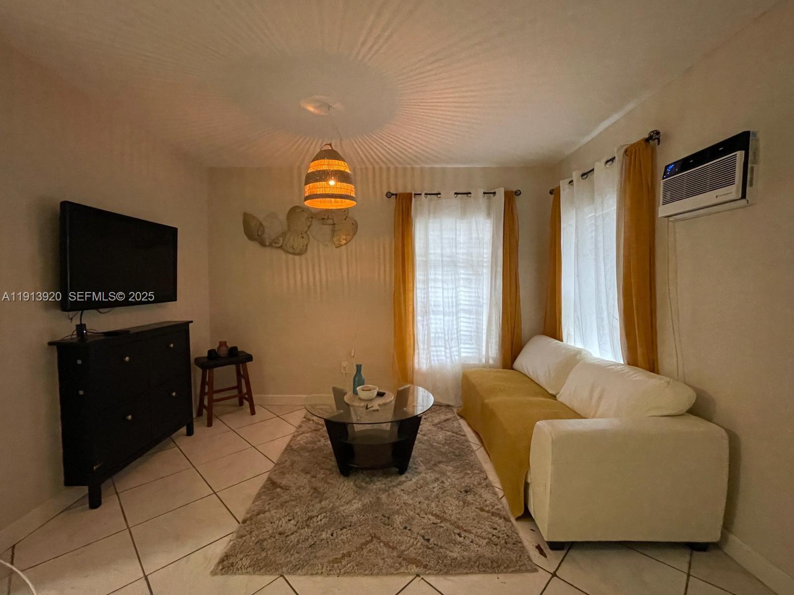 55 Northwest 69th Street, Unit W Miami, FL 33150 - Photo 5 of 8 a living room with furniture and a flat screen tv