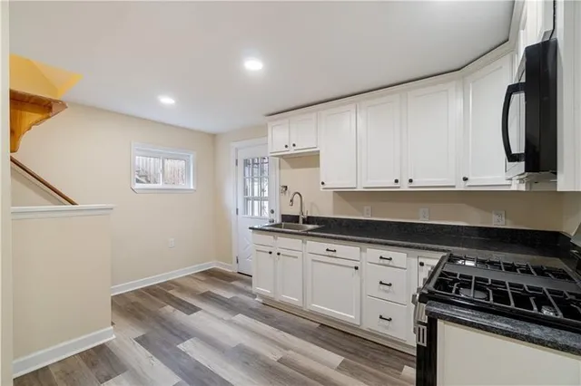 a kitchen with granite countertop a stove and a sink
