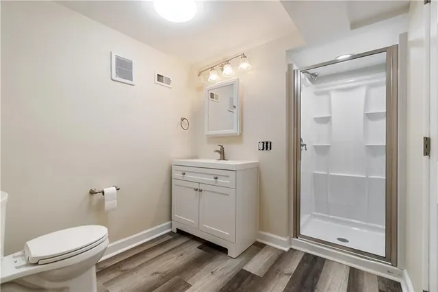 a spacious bathroom with a toilet a sink and mirror