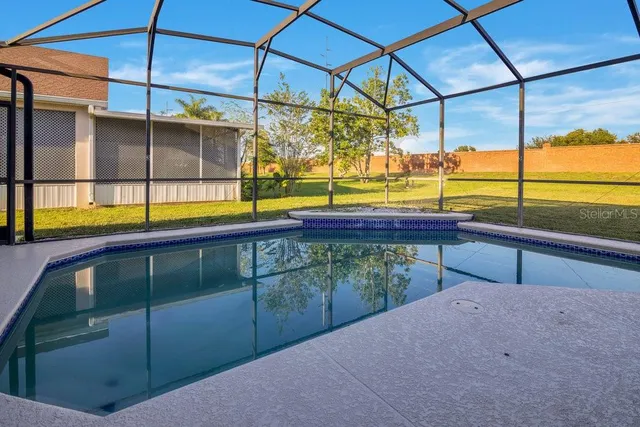 a view of a swimming pool with a yard and sitting area