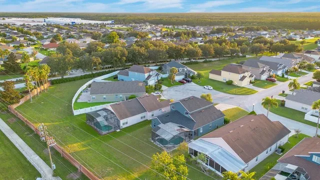 an aerial view of a city with lots of residential buildings ocean and mountain view in back