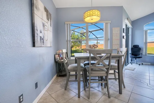 a view of a dining room with furniture a chandelier and a window