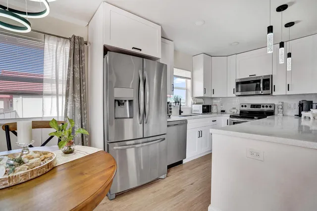 a kitchen with stainless steel appliances a refrigerator sink and microwave