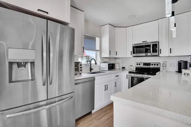 a kitchen with white cabinets and stainless steel appliances