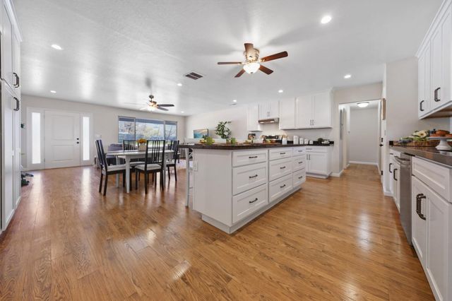 a kitchen with stainless steel appliances granite countertop wooden floors and view living room