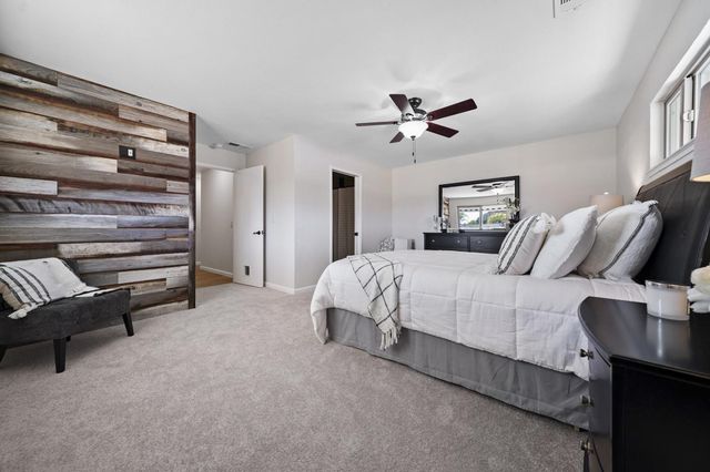 a spacious bedroom with a bed and a chandelier