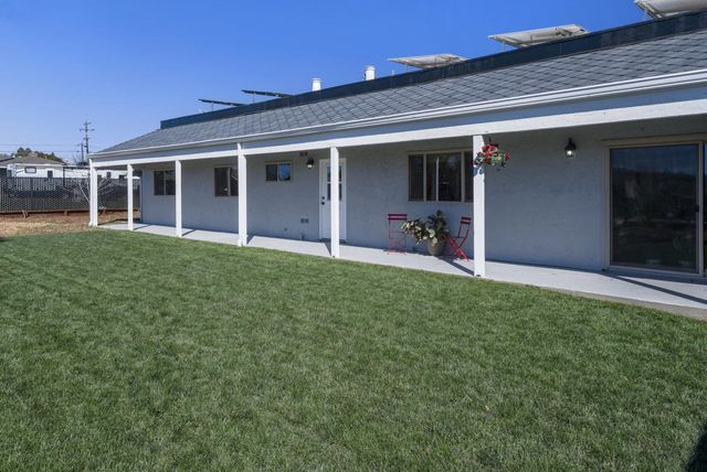 a view of a house with a patio and a yard
